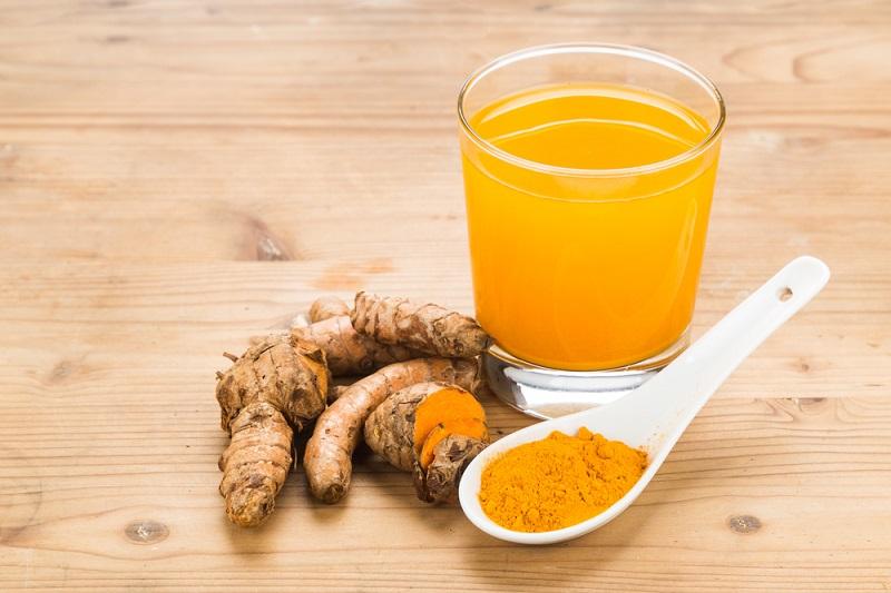 Черновик healthy-turmeric-roots-drinks-in-a-transparent-glass-on-wooden-s